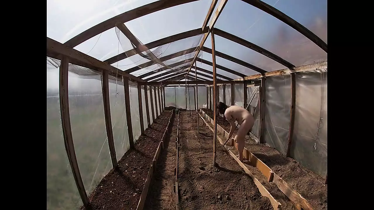 Nude house wife working in the greenhouse